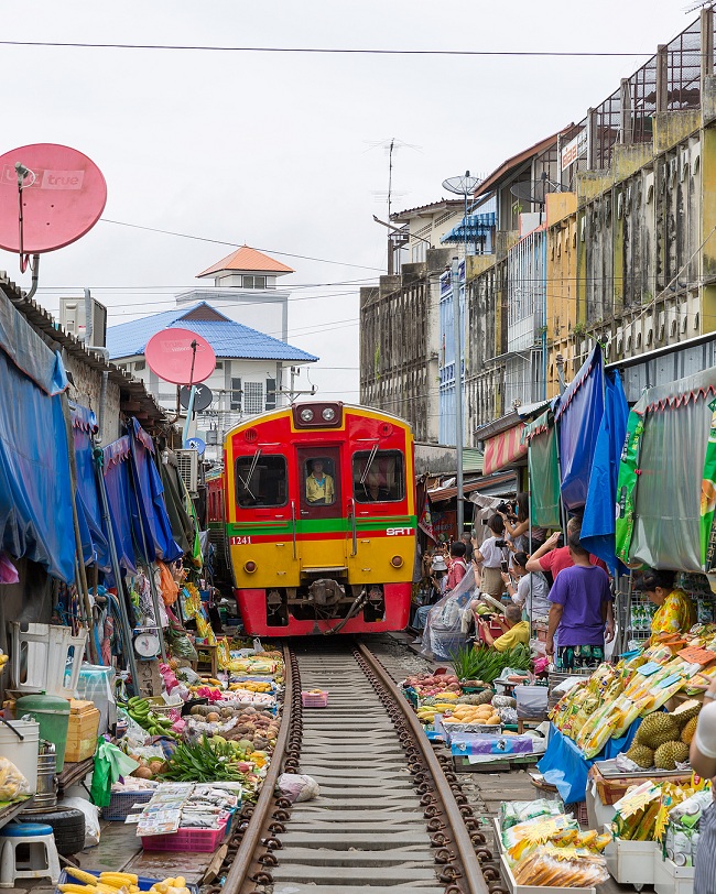 18. Chợ đường sắt Maeklong ở Bangkok, Thái Lan được đặt trực tiếp trên đường ray xe lửa và đoàn tàu đi qua chỉ cách vài cm trước các quầy hàng.