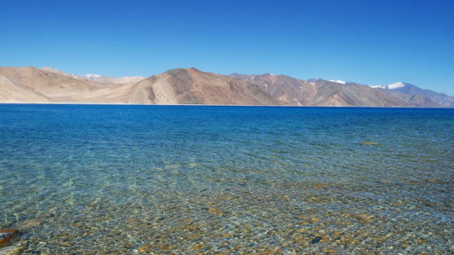 Hồ Pangong Tso, Ladakh: Du khách mất ít nhất khoảng 5 giờ lái xe qua đoạn đường nguy hiểm để tới Pangong Tso, nhưng khung cảnh ngoạn mục của hồ nước trong xanh nằm dưới chân dãy núi Himalaya cũng xứng đáng với công sức bỏ ra.