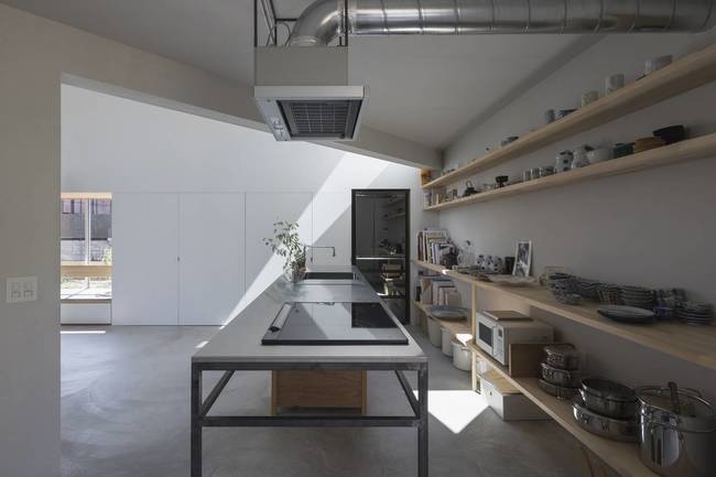 Phòng bếp nằm liền kề phòng đón nắng. Cách đặt các bức tường xéo bên trong giúp tạo nhiều khoảng không gian bao quanh tường chính của ngôi nhà, tăng khả năng kết nối với bên ngoài.
