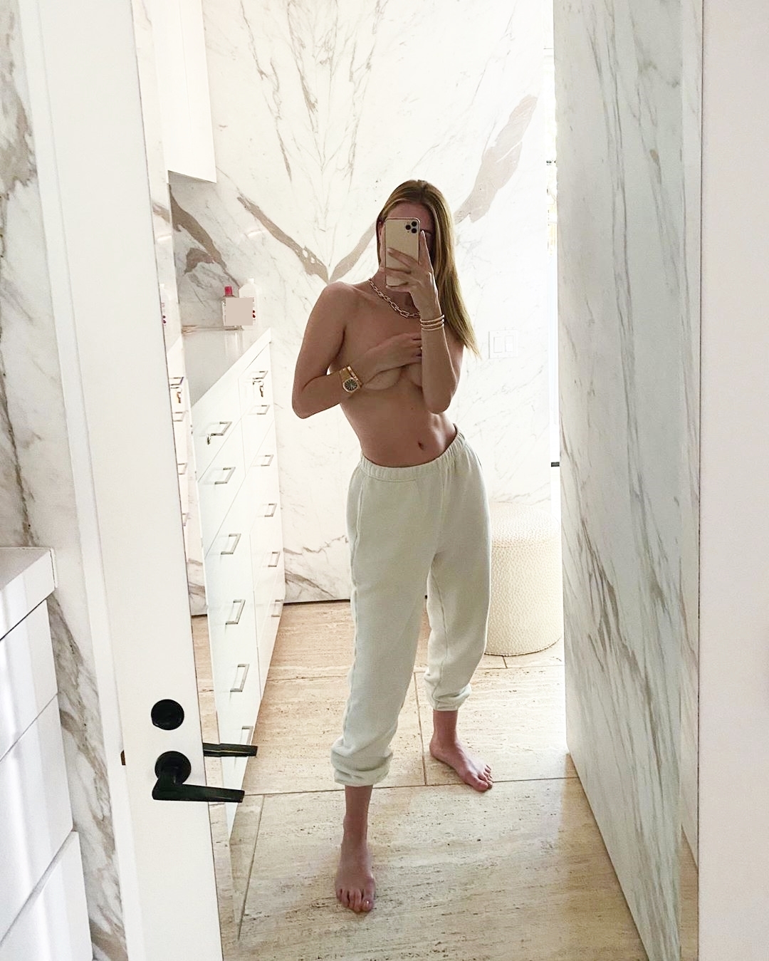Rosie Huntington-Whiteley mặc quần màu trắng chụp ảnh bán nude trước gương.