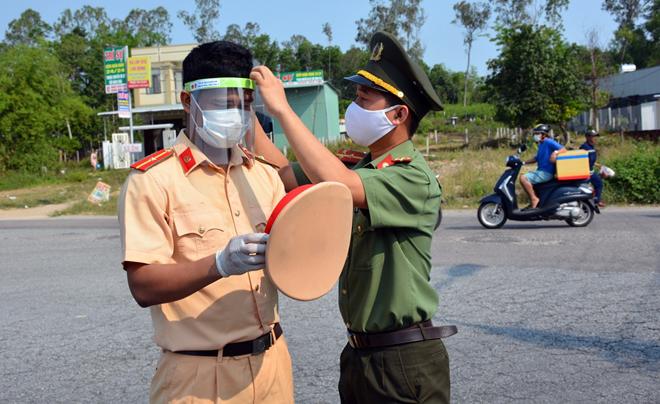 Thượng úy Phạm Hoàng Hồng Minh đeo mặt nạ&nbsp;phòng dịch cho CBCS ở "tuyến đầu" phòng chống dịch.