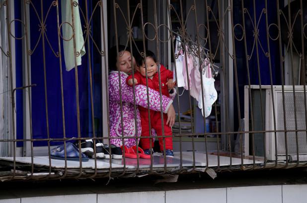 Một em bé cùng mẹ tại một ngôi nhà ở Vũ Hán, tỉnh Hồ Bắc, Trung Quốc. Ảnh:&nbsp;Reuters