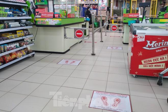 Một siêu thị lớn ở Hà Nội dựng tấm dán dấu chân quy định chỗ đứng của khách hàng khi thanh toán đã bắt đầu xuất hiện.