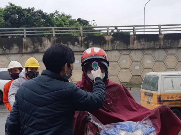 Mọi người qua các điểm chốt vào phường đều được nhân viên y tế đo thân nhiệt