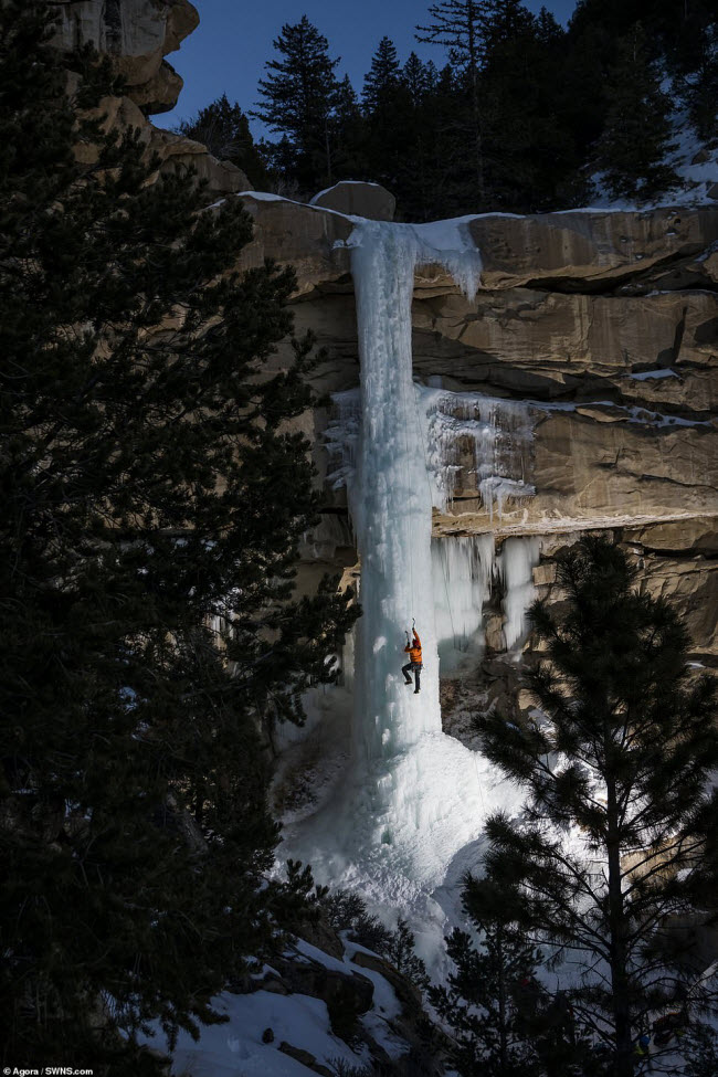 Một người leo núi chinh phục thác nước đóng băng vào ban đêm ở bang Utah, Mỹ.
