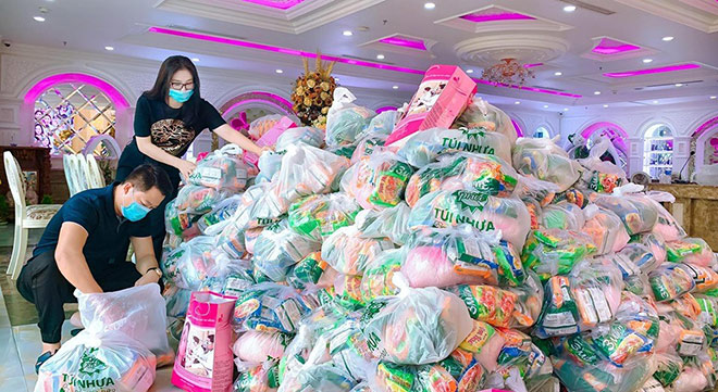 Chị Phan Thị Mai cùng anh Hoàng Kim Khánh tự tay chuẩn bị từng gói quà để phát cho người dân.