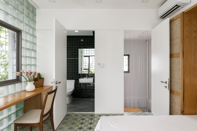 Khác với tầng 2, tầng 3 không sử dụng lớp cửa kính lá chuối để ngăn cách phòng ngủ với nhà vệ sinh. Thay vào đó, một bức tường màu trắng mỏng được dùng để phân chia không gian.