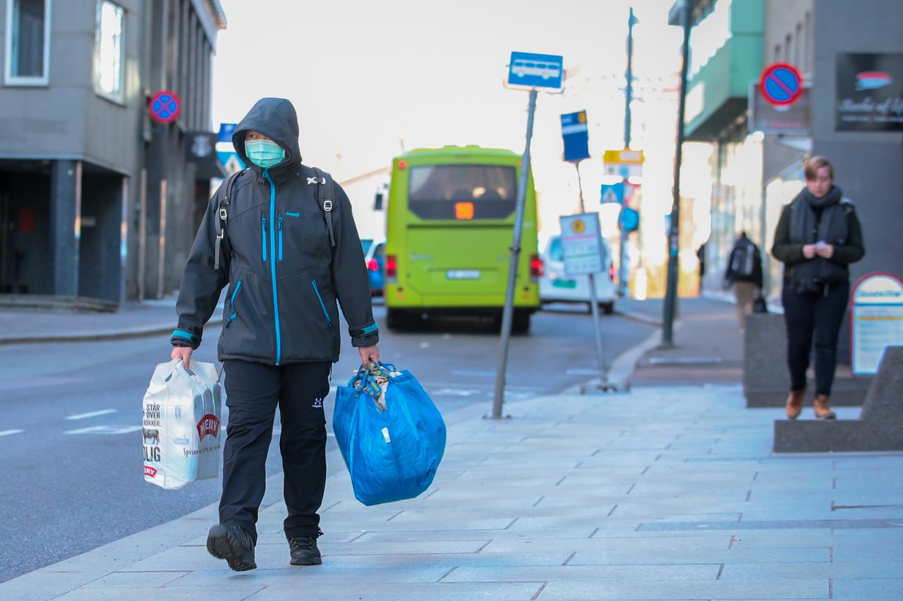 Người dân ra ngoài mua thực phẩm trên đường phố vắng vẻ tại Na Uy trong dịch Covid-19 (ảnh: Reuters)