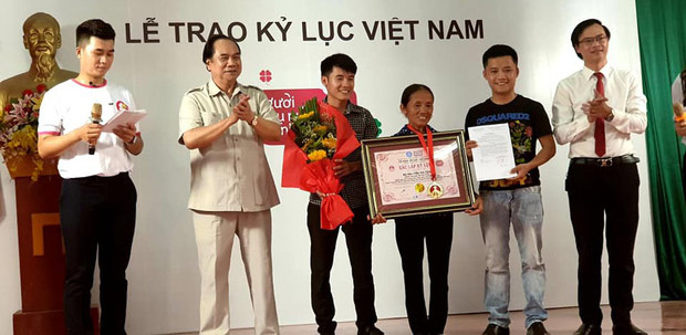 Bà Tân cùng hai con trai trong lễ nhận kỷ lục Việt Nam vào tháng 6 năm ngoái