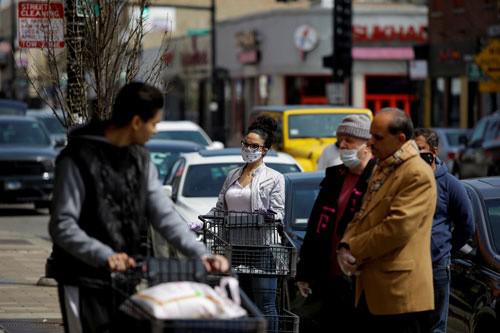 Người dân đeo khẩu trang mua nhu yếu phẩm tại một cửa hàng ở TP Chicago - Mỹ hôm 11-4 Ảnh: REUTERS