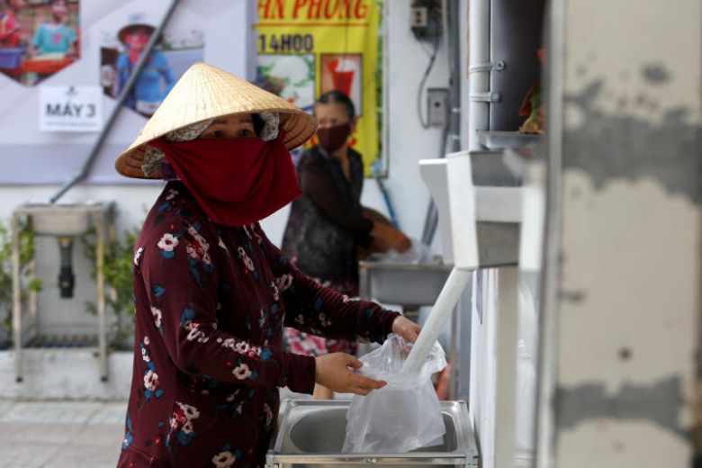 Người dân tới lấy gạo ở "ATM gạo". Ảnh: Reuters