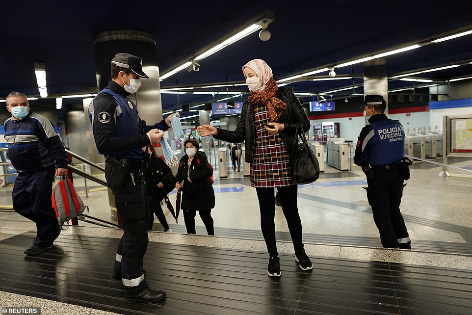 Cảnh sát có mặt ở ga tàu điện ngầm, phát khẩu trang cho người đi làm.