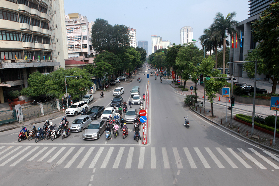 Người dân đứng chờ đèn đỏ trên phố Huỳnh Thúc Kháng