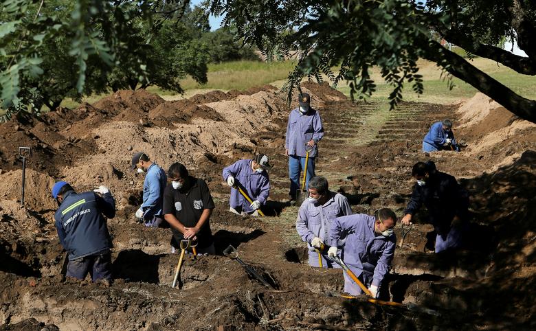 Đào huyệt cho những nạn nhân của dịch Covid-19 (ảnh: Reuters)