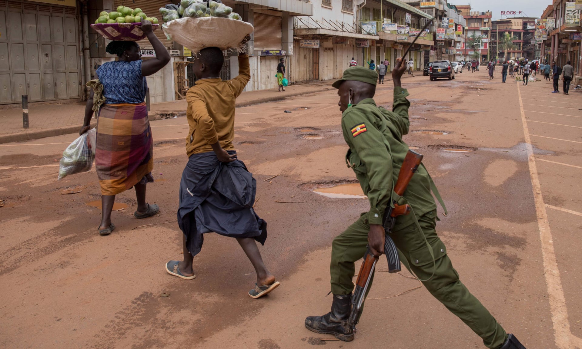 Cảnh sát xua đuổi những người phụ nữ đi họp chợ trong dịch Covid-19 tại Uganda (ảnh: Reuters)