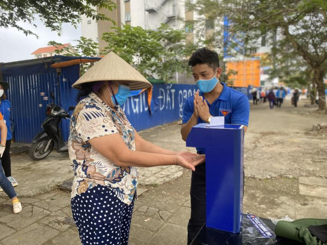 Bí thư Đoàn phường Cấu Đất hướng dẫn người dân rửa tay sát khuẩn.