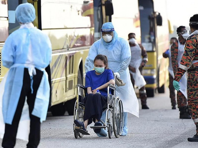 Nhân viên y tế di chuyển bệnh nhân COVID-19 ở Malaysia ngày 14-4. Ảnh: REUTERS