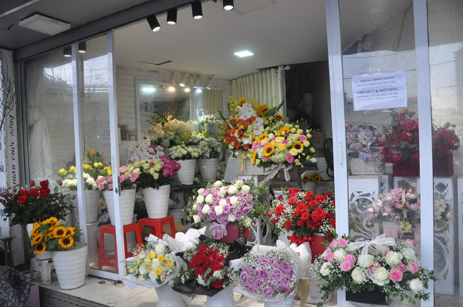  Chị Hoa, chủ cửa hàng chuyên bán hoa tươi tại đường Láng (Đống Đa), cho biết dù mở cửa nhưng từ sáng chưa có khách lẻ đến mua hoa, chủ yếu chỉ phục vụ đơn đặt hàng cho khách quen.