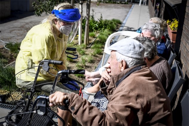 Nhân viên chăm sóc mặc đồ bảo hộ, che mặt bằng kính khi chăm sóc cho người già tại viện dưỡng lão (ảnh: Daily Mail)