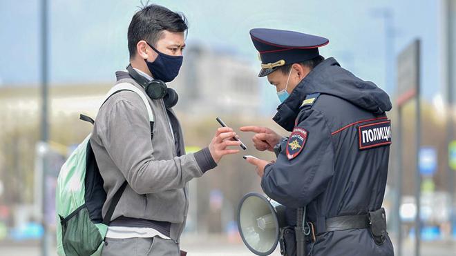 Cảnh sát Nga kiểm tra giấy tờ đi lại của một người đàn ông giữa dịch COVID-19. Ảnh: ITN