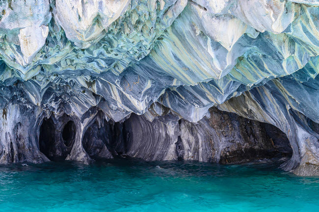 Hang Cẩm thạch Chile: Hệ thống hang động ở Chico được hình thành cách đây 6.200 năm và du khách chỉ có thể tiếp cận bên trong bằng thuyền nhỏ. Trần của hang động thay đổi màu sắc tùy thuộc vào mực nước và mùa.
