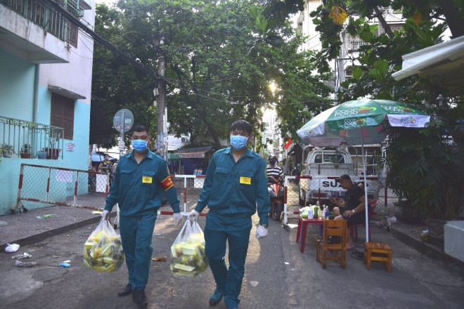 Cán bộ dân phòng mang cơm cho người dân, hỗ trợ vận chuyển đồ cho người dân nếu có nhu cầu.