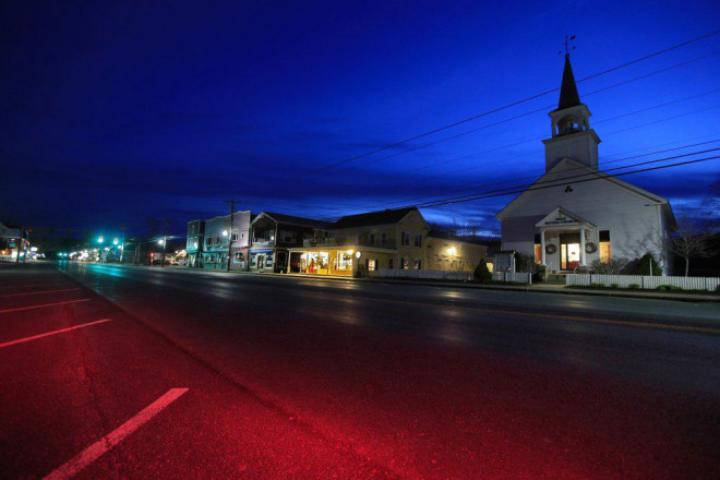 Ở bang New Hampshire - Mỹ, nhà thờ và các cửa hàng nhỏ ở ngôi làng North Conway vắng vẻ, tịch mịch dưới bầu trời hoàng hôn. Ảnh: Robert F. Bukaty