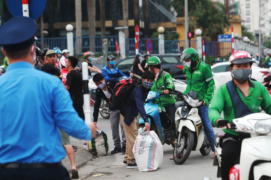 Tại cổng bến xe Mỹ Đình, lực lượng thanh tra giao thông nhắc nhở&nbsp;xe ôm công nghệ di tản, không tập trung đông đúc bắt khách.