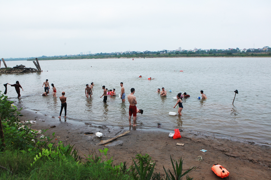 Những ngày đầu tháng 5, nhiệt độ Hà Nội nắng nóng lên đến gần 40 độ C. Rất nhiều người đổ xô ra khu vực bãi giữa sông Hồng để “tắm giải nhiệt” vào mỗi buổi chiều