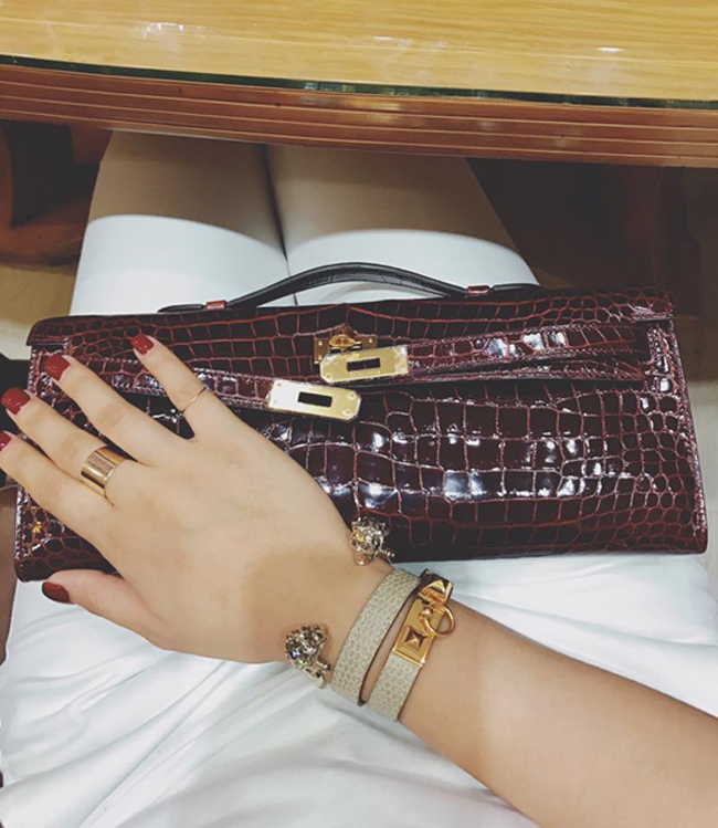 Mẫu clutch da cá sấu này có tên Hermes Shiny Porosus Crocodile Kelly, có giá bán lên đến 800 triệu đồng. Ngoài ra là chiếc vòng Alexander McQueen có giá khoảng 7 triệu đồng.
