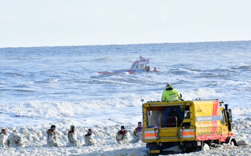 Nhân viên cứu hộ vật lộn với đám bọt biển để tìm kiếm những người lướt sóng mất tích. Ảnh: VRP