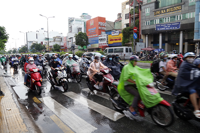 Người dân lưu thông trên đường Cộng Hòa (quận Tân Bình) trong cơn mưa chiều 16/5.