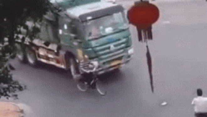 SỐC: Lái xe đạp sang đường bị xe tải cuốn chui vào gầm - 1