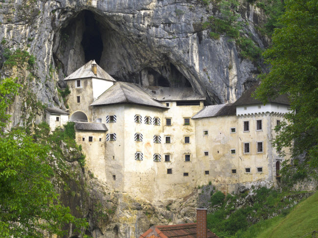 Postojna, Slovenia: Trước cửa hang động là lâu đài Predjama được xây trên vách núi. Dưới lâu đài này là một công trình ngầm với các đường hầm bí mật.
