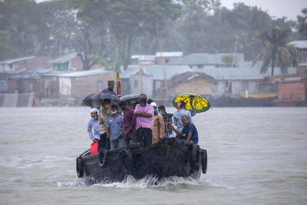 Người dân Bangladesh tranh thủ đi thuyền qua sông khi bão ập đến.