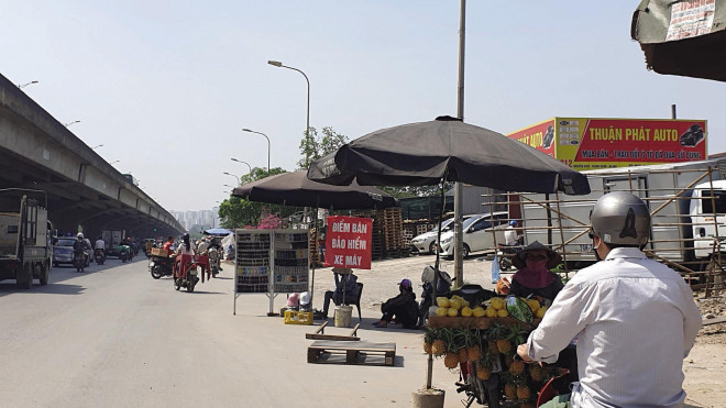 Một góc “chợ” bảo hiểm xe máy ở vỉa hè phố Nguyễn Xiển (Thanh Trì, Hà Nội). Ảnh: Bảo Loan