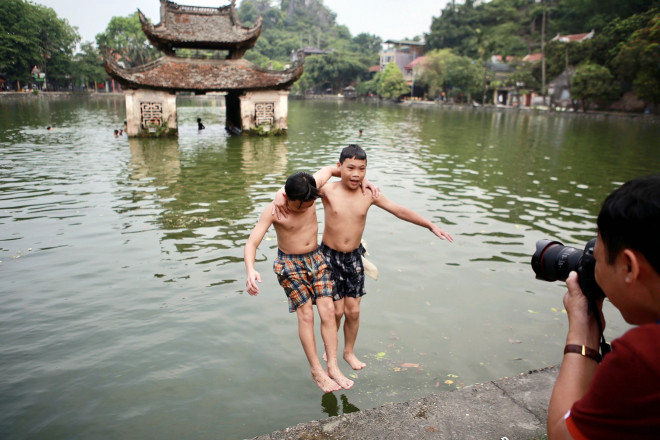 Hai em nhỏ vui chơi bên hồ Long Trì thuộc quần thể di tích Chùa Thầy xã Sài Sơn.