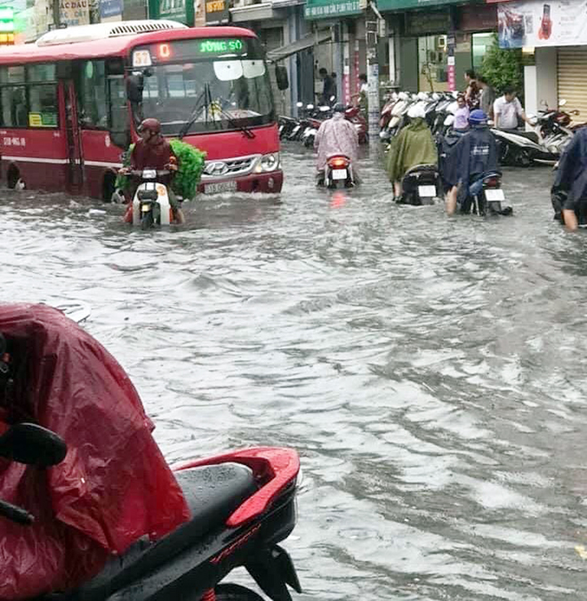 Người phụ nữ mệt mỏi vì xe chết máy, không biết đi hướng nào để tránh ngập. “Đường này mưa là ngập. Nhìn đường mà cứ như sông vậy. Tội nhất là mấy chị em phụ nữ chở con nhỏ phải gồng mình vượt qua nước ngập”, anh Đặng Giang ngụ quận Thủ Đức nói.