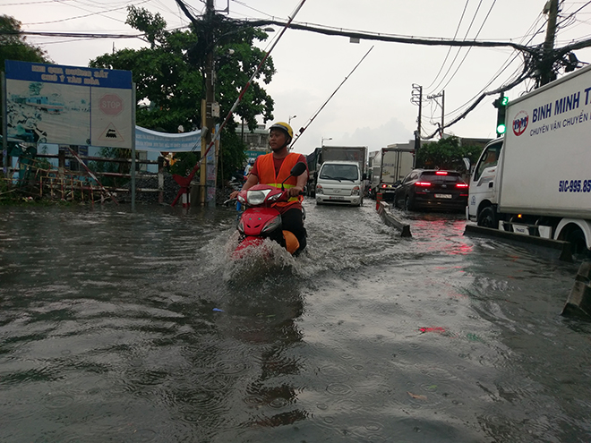 &nbsp;Người dân rẽ sóng nước về nhà chiều cuối tuần. Người dân địa phương cho biết đường Tô Ngọc Vân có mặt đường thấp cộng với nước đổ về đây quá nhiều khiến các cống, rãnh không kịp thoát nước.