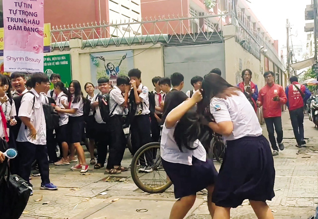 Nữ sinh Trường THCS Hoàng Văn Thụ (quận 10, TP HCM) đánh nhau trước khu vực cổng trường. Ảnh cắt từ clip. (Ảnh: Gia đình và Xã hội).