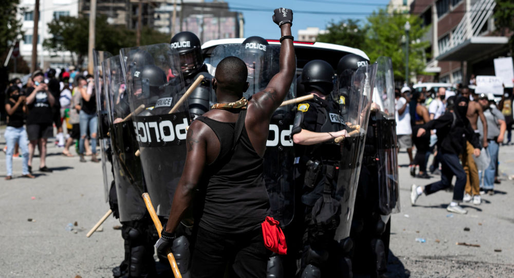 Một người da đen đứng trước nhóm cảnh sát chống bạo động tại Mỹ (ảnh: AP)