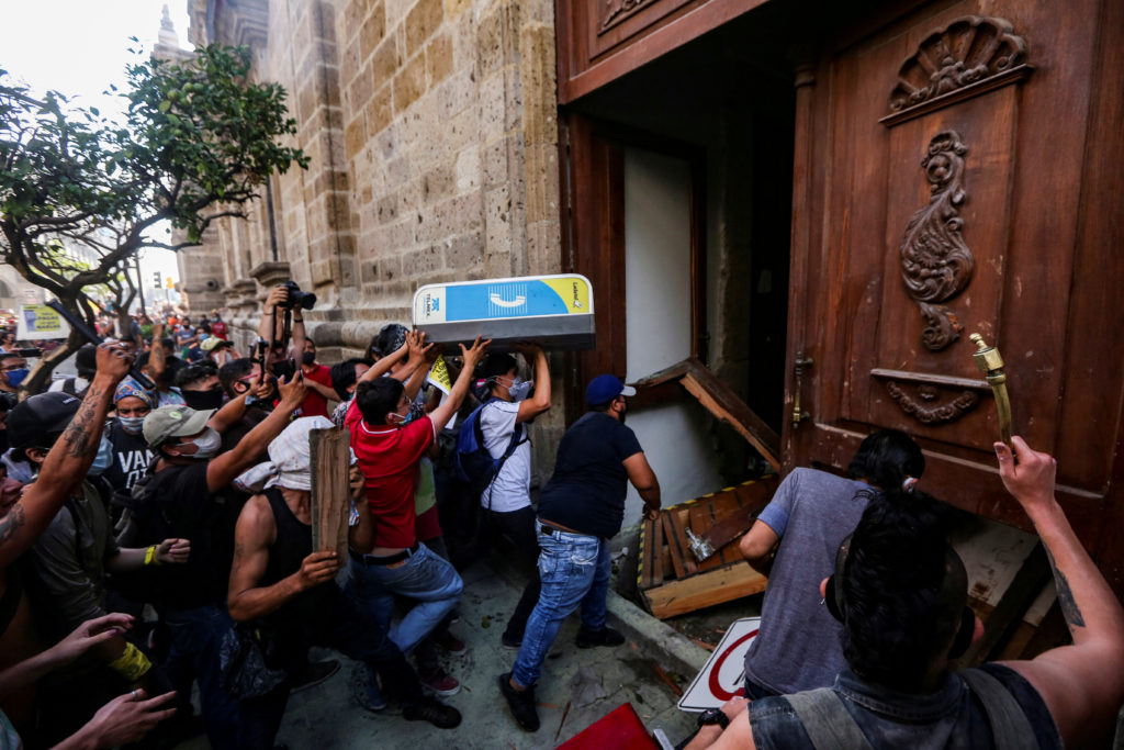 Người biểu tình đòi công lý&nbsp;cho&nbsp;Giovanni López&nbsp;tìm cách phá cửa vào dinh thống đốc bang&nbsp;Jalisco (Ảnh: Reuters)