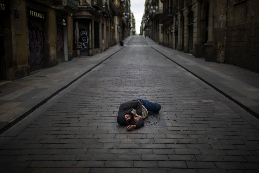 Một người đàn ông ngủ giữa đường phố tại Tây Ban Nha trong dịch Covid-19 (ảnh: AP)