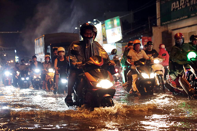 Người dân phải rẽ sóng nước để về nhà sau cơn mưa 40 phút. “Cái này nhiều năm rồi mà. Mưa là ngập nên riết rồi cũng quen. Chỉ sợ đang chạy xe trên đường ngập mà bị lọt ống cống, hố ga thì khổ”, anh Nguyễn Văn Phùng ngụ quận Bình Thạnh nói.