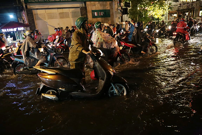 Nhiều người bì bõm lội bộ vì xe hư hỏng, chết máy. “Lội nước mệt nghỉ luôn. Vừa đẩy xe chết máy vừa lội nước có gần 1km chứ mấy, giờ thở không ra luôn”, người phụ nữ tên Linh chia sẻ.