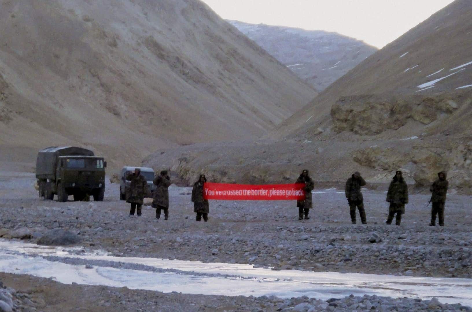 Quân đội Trung Quốc cầm một biểu ngữ có dòng chữ: "Các ông đã vượt qua biên giới, hãy mau quay lại" ở khu vực&nbsp;Ladakh, năm 2013. Ảnh: AP