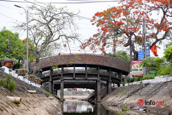 Mùa hè, hoa phượng nở đỏ thắm, điểm tô sắc màu&nbsp;vào nét cổ kính của cây cầu, tạo nên một khung cảnh thôn quê bình yên, dân dã mà hấp dẫn lạ kỳ.