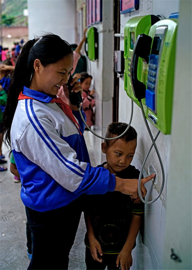 Một cô bé đang gọi điện cho cha mình qua điện thoại. Ngôi làng vách đá nói lời tạm biệt với thời đại không giao tiếp. Với điện thoại di động, các sản phẩm bản địa có thể dễ dàng được bán trên thị trường.