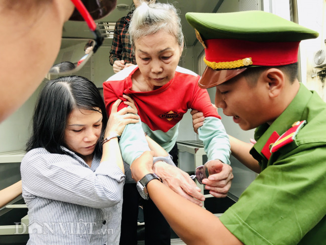 Bị cáo Trịnh Thị Hồng Hoa không thể tự đi được nên được bị cáo Huyên cùng lực lượng cảnh sát hỗ trợ dìu vào phòng xét xử. Ảnh: V.D