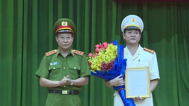 Thượng tướng Lê Quý Vương trao quyết định và chúc mừng Đại tá Lê Hồng Nam. (Ảnh: CAND)